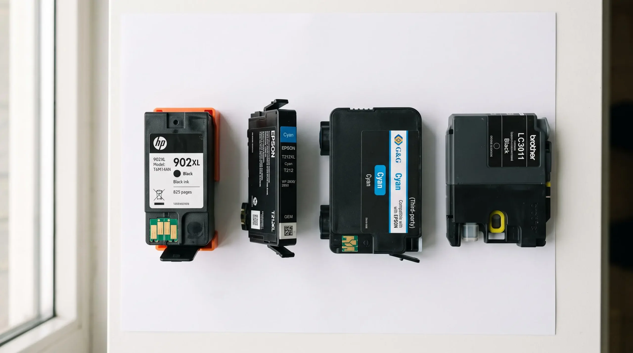 Multiple ink cartridges of different types arranged on white surface showing physical comparison